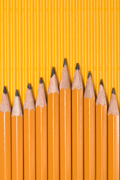вид сверху графитовых карандашей, расположенных рядами на желтом
 - Фото, изображение