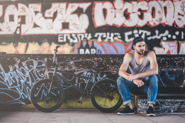 Young man in skatepark. Male teenager with BMX bike. Professional BMX rider. - Fotó, kép