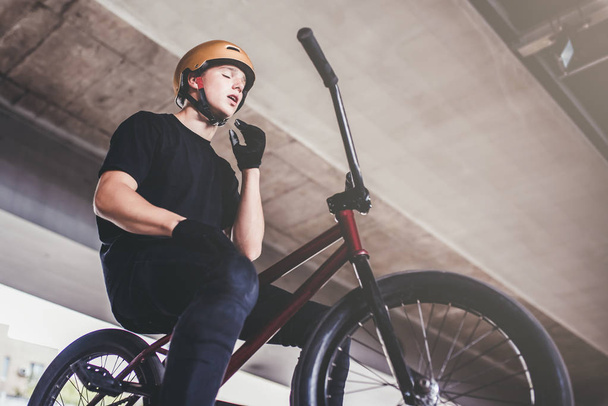Teenage BMX rider is performing tricks in skatepark. - 写真・画像