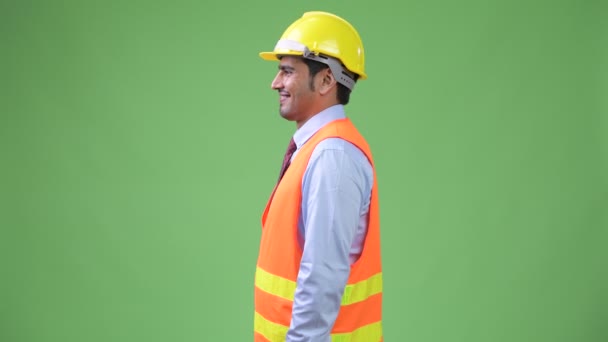 Profile view of young handsome Persian man construction worker - Materiaali, video
