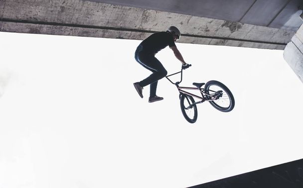 Teenage BMX rider is performing tricks in skatepark. - Foto, Bild