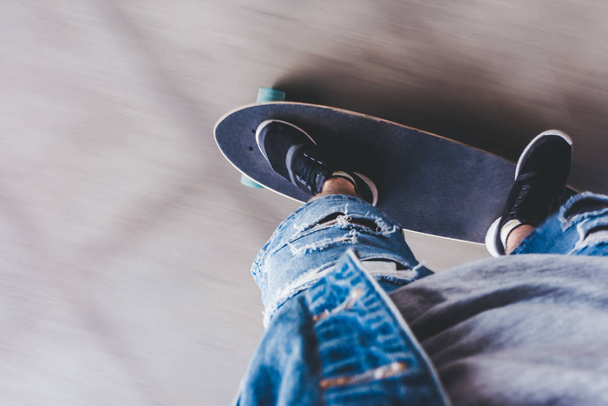 Cropped image of young man skateboarder. Male teenager with longboard in skatepark. - Foto, imagen