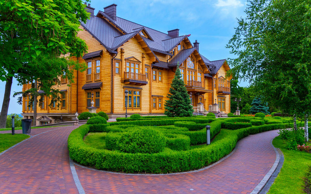 A beautiful wooden mansion from pine decks and a flowerbed in front of it - Фото, зображення