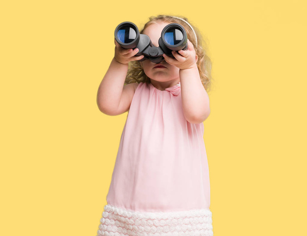Lovely blond toddler looking through binoculars - Zdjęcie, obraz