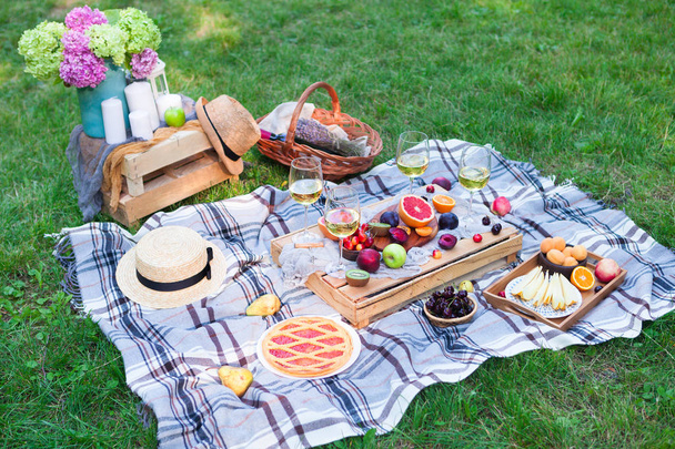 Picnic background with white wine and summer fruits on green grass - Fotoğraf, Görsel