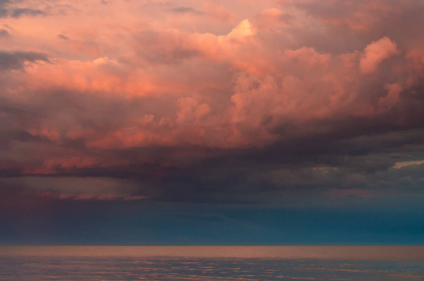 Büyük thunderclouds mor Azak Denizi üzerinde batan güneşin, deniz ufuk yaktı. Su yüzeyinde yansıma. - Fotoğraf, Görsel