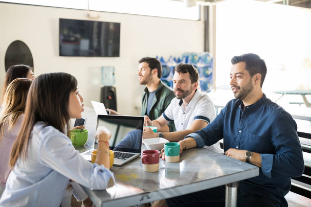 Молода ділова команда в офісних кафетеріях обговорює ідеї під час розмови під час перерви на каву
  - Фото, зображення