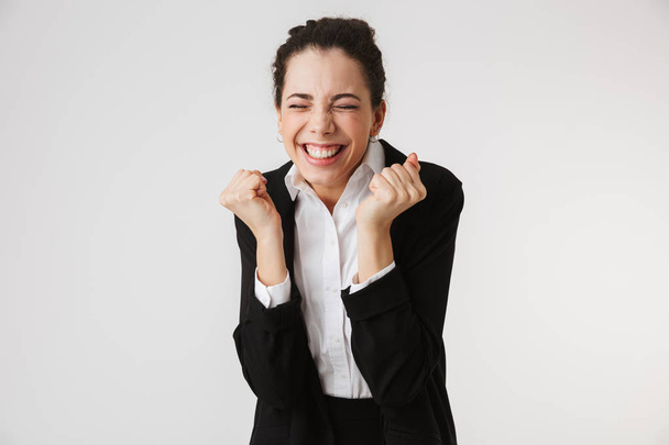 Portrait of an excited young businesswoman celebrating winnery isolated over white background - Fotoğraf, Görsel