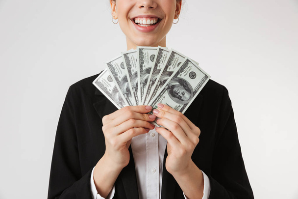 Cropped photo of young business woman holding money isolated over white wall backgound. - Foto, Bild