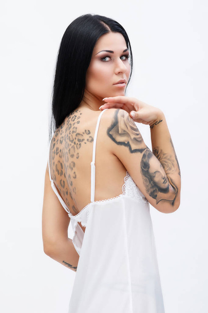 Woman with tattoos wearing beautiful nightgown - Photo, Image