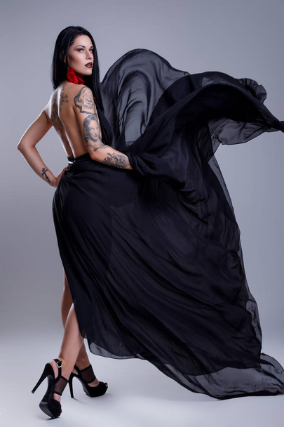 Portrait of woman with tattoos wearing black dress - Zdjęcie, obraz