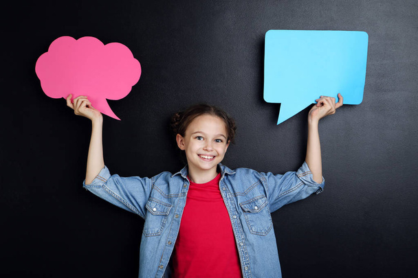 Young girl with speech bubbles on blackboard background - Foto, immagini