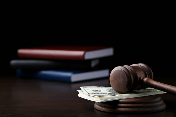 Judge gavel with dollars and books on wooden table - Foto, Imagen