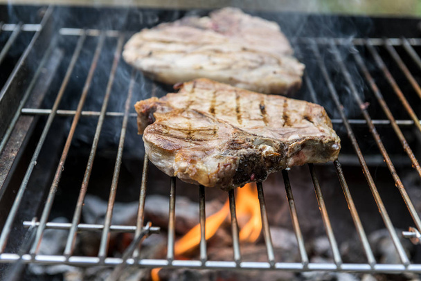 T-Bone hakken varkensvlees op het rooster van de barbecue - Foto, afbeelding