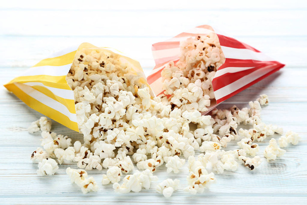 Popcorn in paper bags on wooden table - Foto, Bild