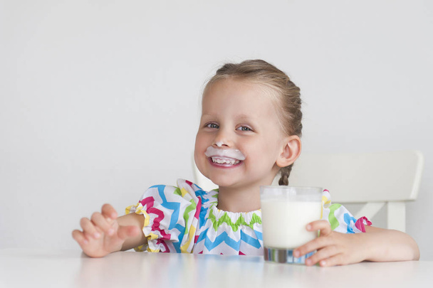 カメラを見てミルクを飲みながら美しい少女 - 写真・画像