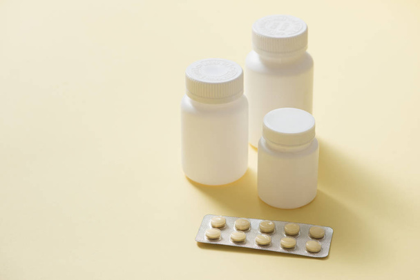 Pills boats white with white tablets of different types on yellow background - Foto, afbeelding
