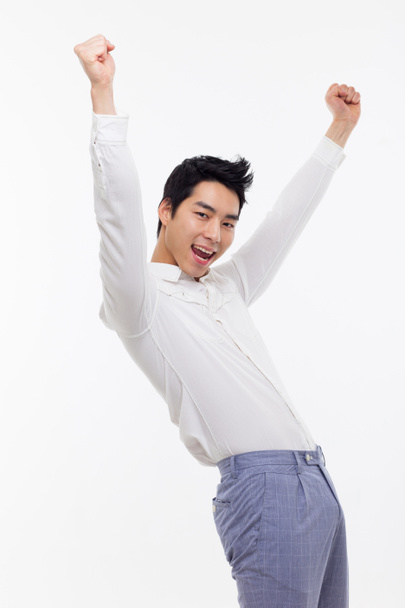 Jeune homme asiatique montrant poing et signe heureux
. - Photo, image