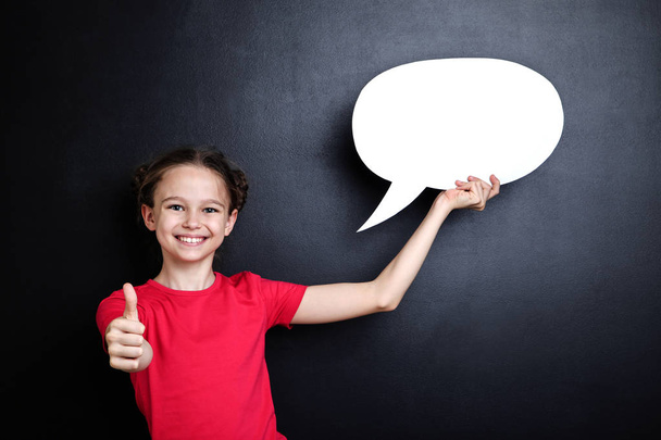 Young girl with speech bubble on blackboard background - Zdjęcie, obraz