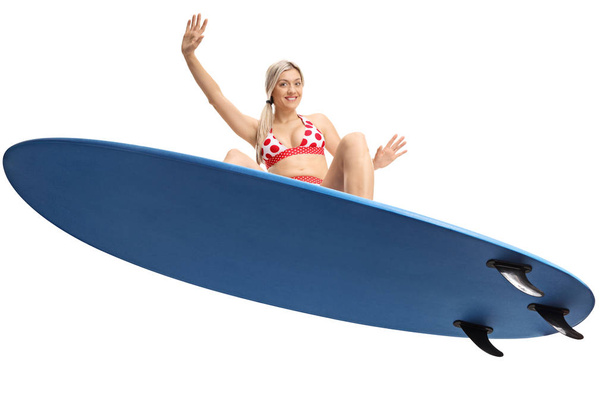 Female surfer jumping with a surfboard isolated on white background - Fotografie, Obrázek