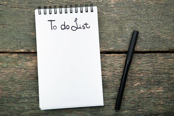 To do list in notepad with felt-tip pen on grey wooden table - Photo, image