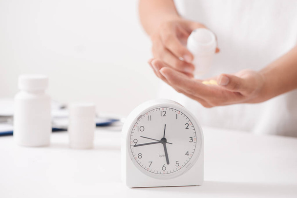 Orvos kezében gyógynövény tabletta, óra, üveg, orvosi idő fogalma - Fotó, kép