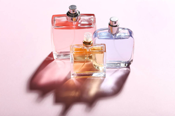 Perfume bottles on pink background - Фото, изображение