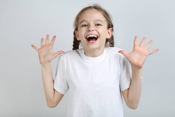 Surprised young girl on grey background - Photo, Image