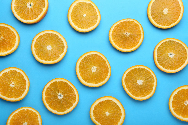 Sliced of orange fruit on blue background - Zdjęcie, obraz