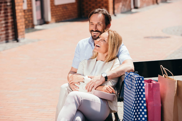 couple heureux étreignant sur le banc après le shopping
 - Photo, image