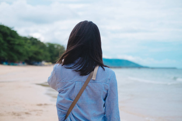 reizen achtergrond achteraanzicht jonge vrouw lopen alleen op strand. afbeelding voor de zomer, persoon, portret, landschap, tropische concept - Foto, afbeelding