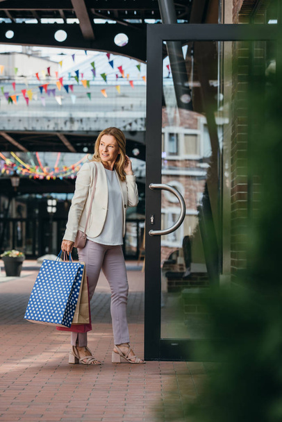 Attractive stylish woman entering shopping mall - Fotografie, Obrázek