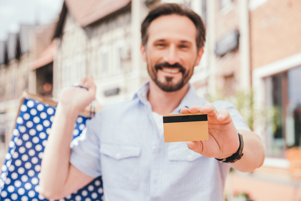 smiling handsome man showing credit card - Zdjęcie, obraz