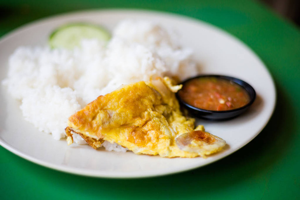 Omelette aux œufs malais fraîchement préparée sur riz au concombre et sambal dans un restaurant local à Malacca. Cuisine asiatique traditionnelle à base d'ingrédients frais
. - Photo, image