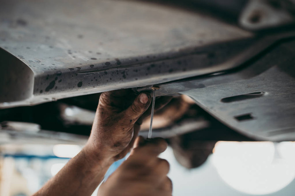 Close up hands of unrecognizable mechanic doing car service and maintenance - Fotografie, Obrázek