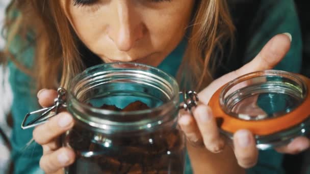 Closeup woman's face smelling freshly roasted coffee from glass jar - video in slow motion - Footage, Video