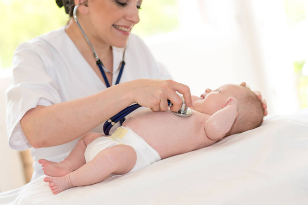 Female pediatrician using stethoscope to examine a little baby - Zdjęcie, obraz