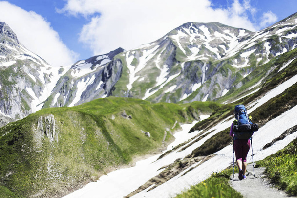 Campaign around Mont Blanc. The girl is walking along the trail with a backpack. - Foto, afbeelding