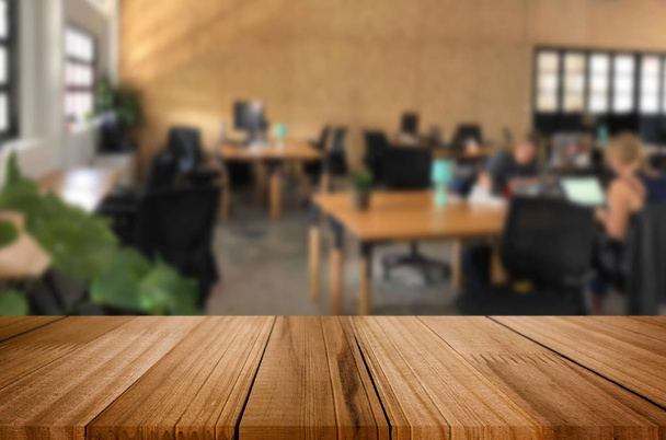 Enfoque seleccionado mesa de madera marrón vacía en la oficina con grandes ventanas del fondo con imagen bokeh. para su fotomontaje o visualización del producto
. - Foto, Imagen