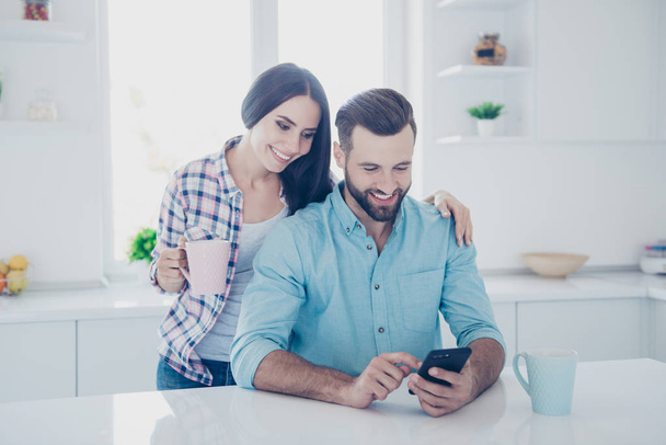 Apps electronic wireless device technology social networks connection communication concept. Portrait of joyful couple watching video on smart phone using wi-fi internet - Foto, afbeelding