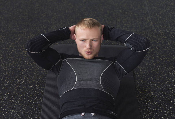 Jongeman fitnesstraining, sit-up crunches voor abs - Foto, afbeelding