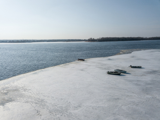 Luftaufnahme des malerischen Flussufers mit schneebedeckten Booten, Kyiw, Ukraine - Foto, Bild