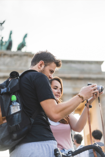 tourists looking at photo camera in front of Brandenburg Gate, Berlin, Germany  - Photo, Image