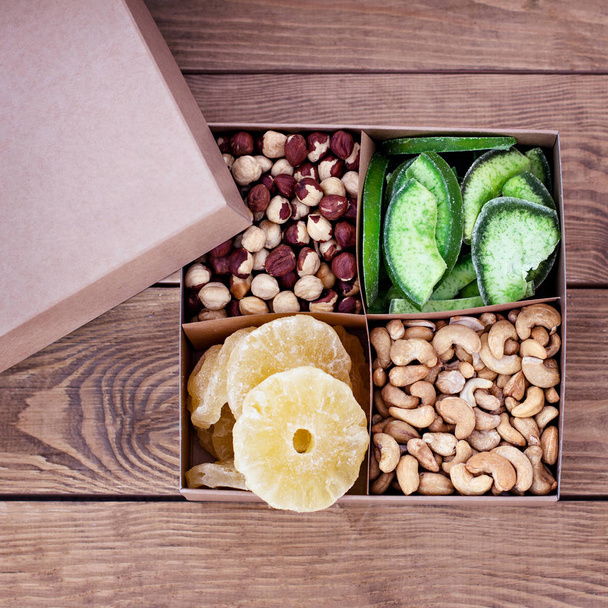 Assorted nuts in a  box (from top left: walnut, brazil nut, pecan, pistachios, almond, macadamia, peanut, cashew, hazelnut) - Fotó, kép