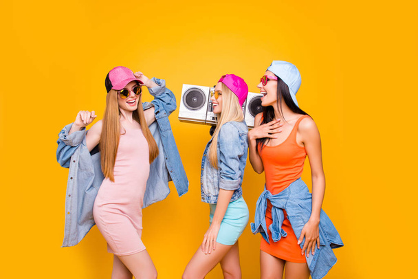 Oldschool culture portable lover fan cassette tape hip-hop rest relax leisure pleasure concept. Portrait of fancy trio enjoying favorite music dancing isolated on bright yellow background - 写真・画像