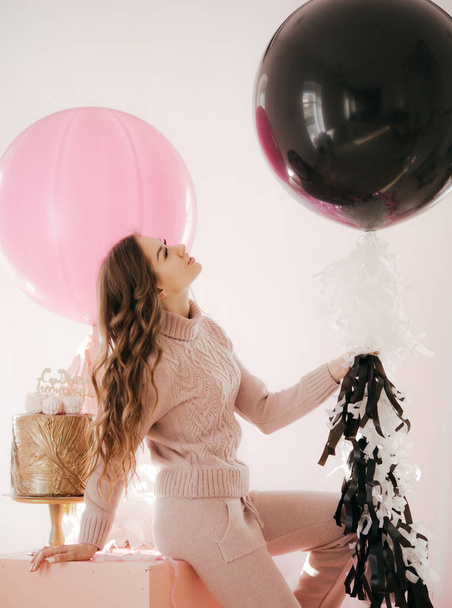 Портрет красивої молодої жінки з макіяжем в стильній сукні позує в студії з повітряними кулями на фоні
  - Фото, зображення