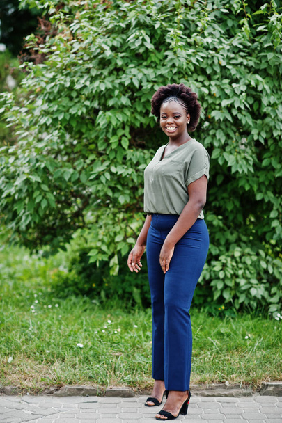 African girl posed at street of city wear on green blouse and blue pants. - Zdjęcie, obraz