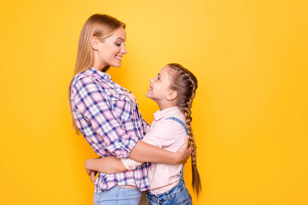 We spend time together! Motherhood parenthood babysitter mama mom mommy mum baby concept. Side profile view portrait of nice cute glad excited with pigtails siblings isolated on bright background - Photo, image