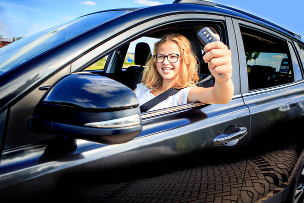 uma jovem depois de conduzir com sucesso exame em um carro
 - Foto, Imagem
