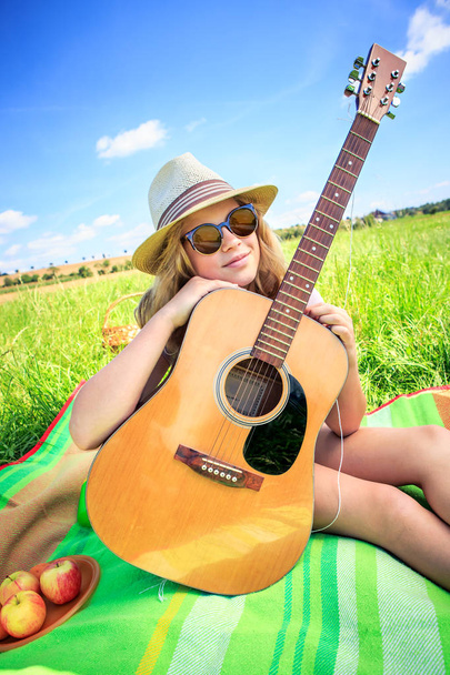 Outdoor portrait of young girl with a guitar - Photo, image